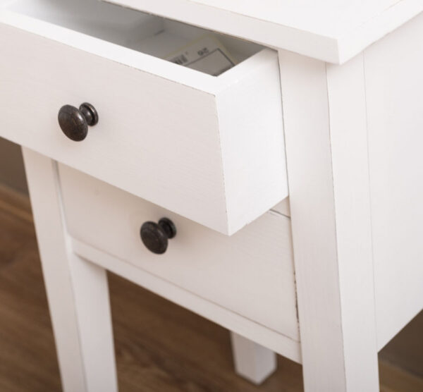 Landelijk nachtkastje met twee kleine lades en hoge pootjes. Gemaakt van massief eiken hout in de kleur wit. Het meubel kan op verschillende manieren geverfd worden in verschillende kleuren en kan op maat gemaakt worden. Villa Laura
